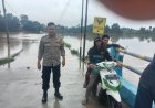 Air Kali Meluap, Personil Polsek Cikampek Aiptu Nana Mulyana Siaga Banjir di Desa Parakanmulya 