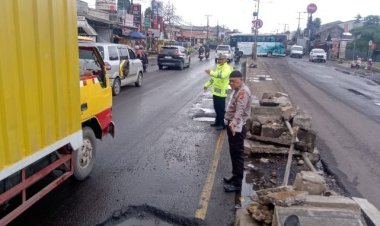 Antisipasi Terjadinya Kemacetan Kendaraan dan Laka Lantas, Unit Lantas Polsek Klari Gatur Lalin di Jalan Berlubang